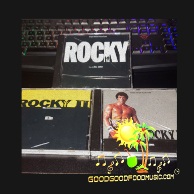 Three CD "Rocky"  movie soundtracks arranged on a black desk.